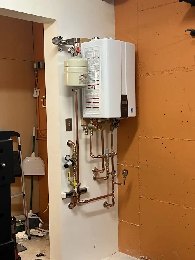 Plumbing technician inspecting water heater connections in East Lyme